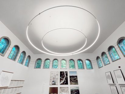 An exhibition with white interiors and a circular lamp