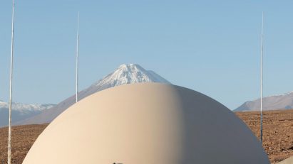 A domed structure in front of the Chilean Andes in the desert