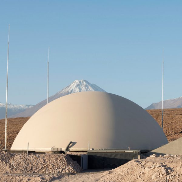 A domed structure in front of the Chilean Andes in the desert