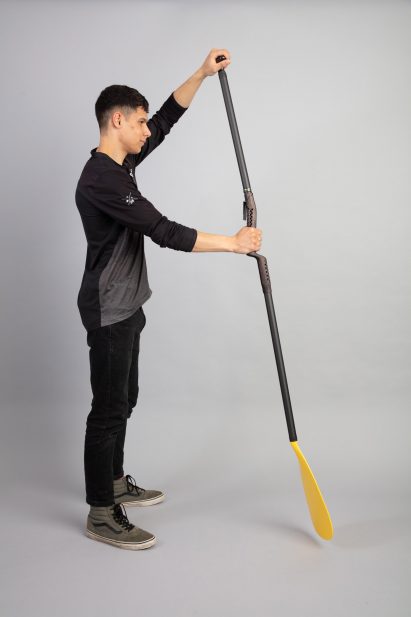 A person holding a black and yellow paddle for paddle boarding
