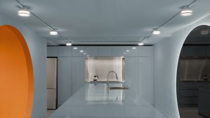 Baby blue kitchen with orange portal on one side and mirror on the other