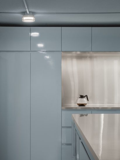 Baby blue kitchen with stainless steel island and backsplash