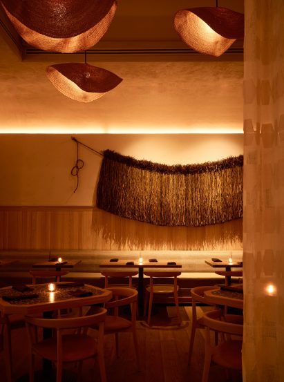 Dining tables beneath a fibre artwork