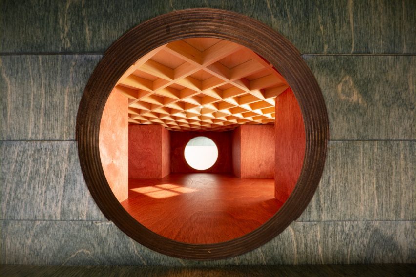 View through a circular window of Carmody Groake's square timber pavilion at the Dulwich Picture Gallery