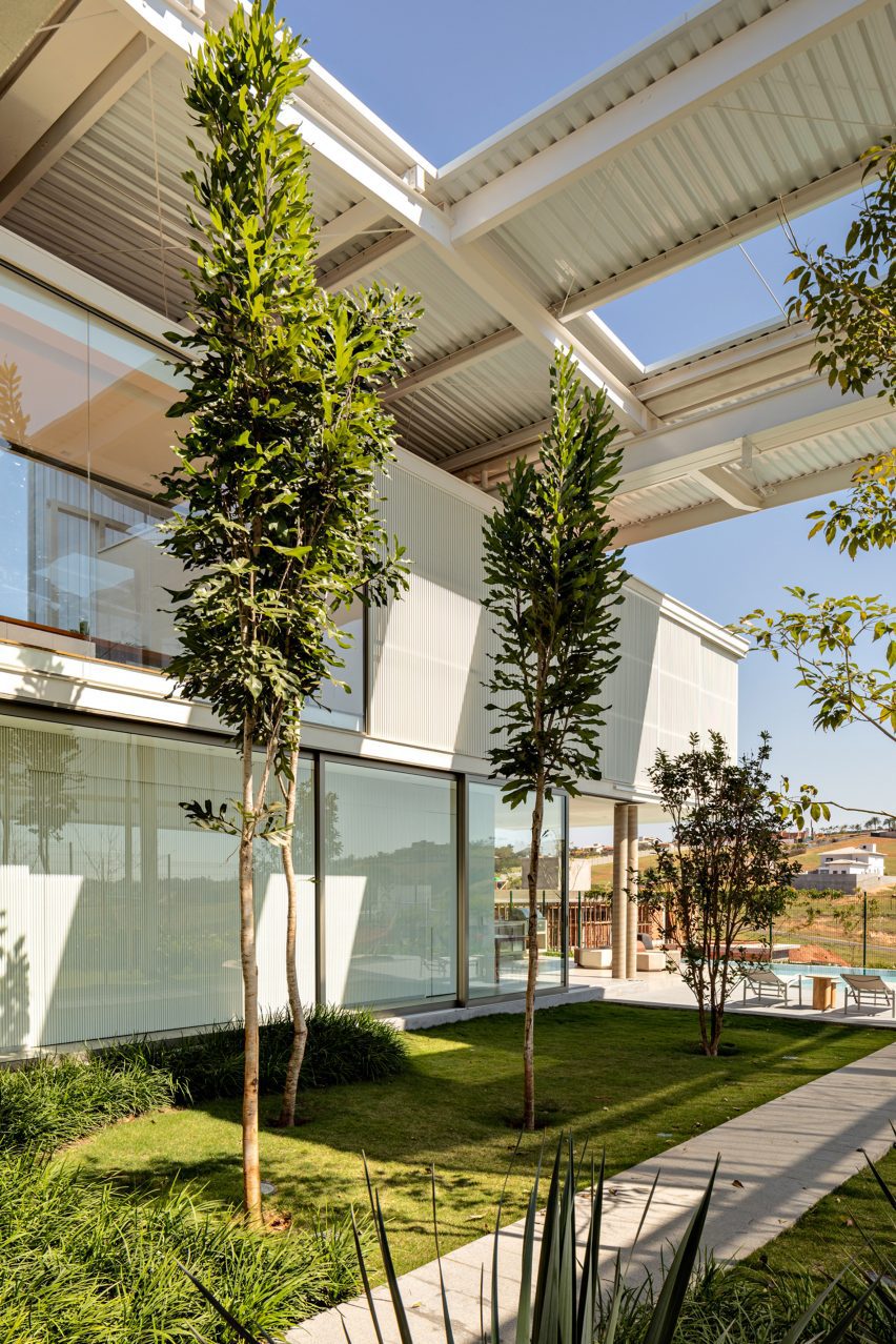 Two trees and grass in front of a contemporary home in Brazil