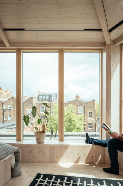 Man sitting on window seat of London extension by Whittaker Parsons