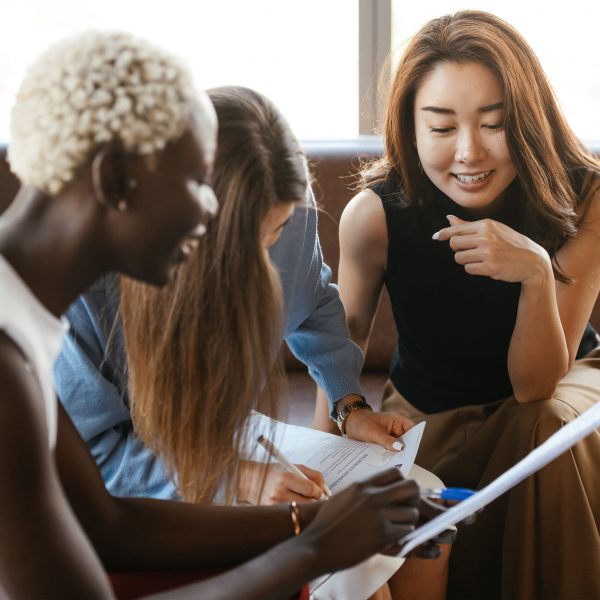 Three women sat together taking notes