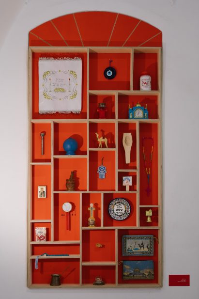 Gridded wooden shelving with traditional Israeli objects displayed