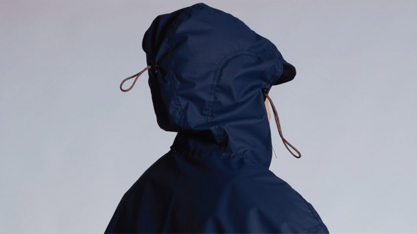 Person wearing a hooded navy windbreaker jacket