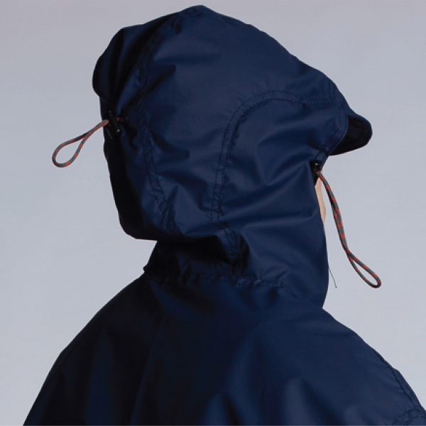 Person wearing a hooded navy windbreaker jacket