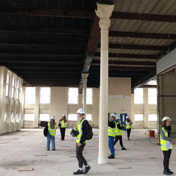Architecture workers in high-vis vests in a double-height space