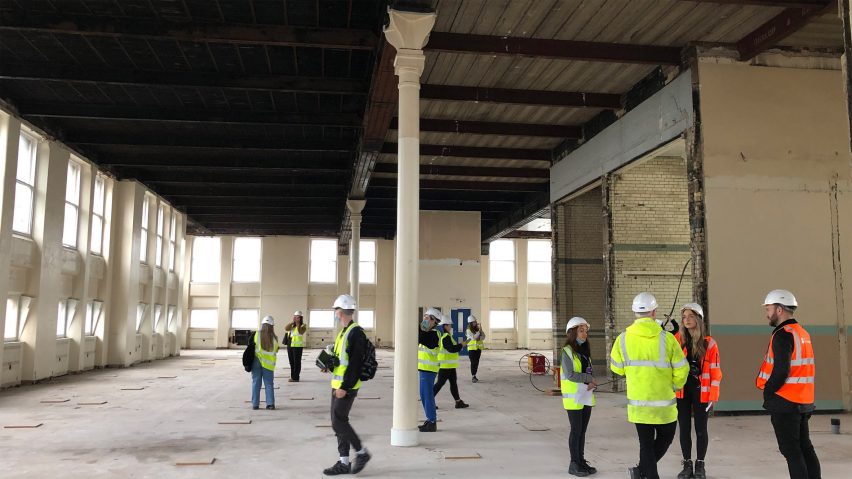 Architecture workers in high-vis vests in a double-height space