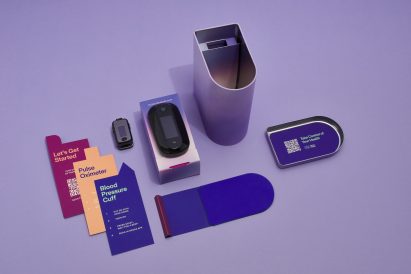 Photo of Spora Health's Momma's Kit unboxed showing the tin next to a oximeter, blood pressure cuff and instruction cards