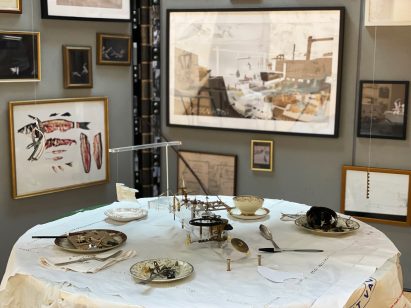 Photograph showing dining table in room with many frames on wall