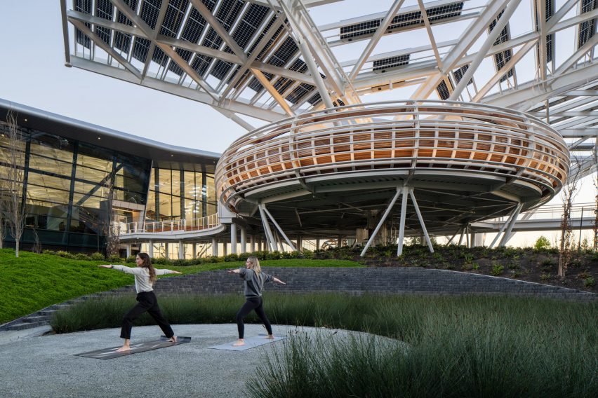 Women in doing yoga in front of structure
