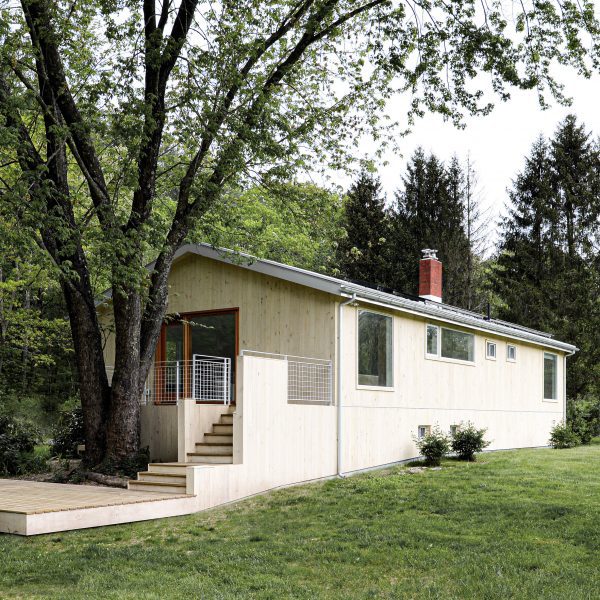Wood-clad ranch house in New York with steps leading to a deck