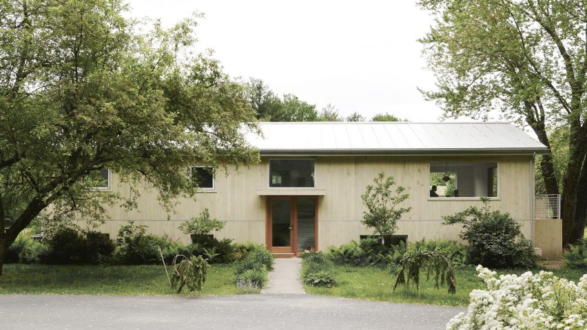 Wood-clad ranch house by Ballman Khapalova with a front garden