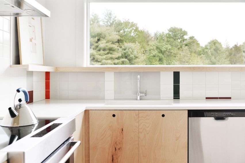 Kitchen with geometric colourful wall tiles and wood kitchen units