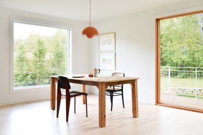 Dining room with white walls, wood flooring and a wood dining table