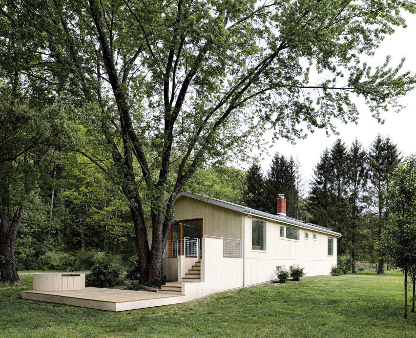 Wood-clad ranch house in New York with steps leading to a deck