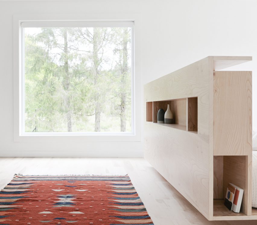 Bedroom with a red rug a wooden storage unit