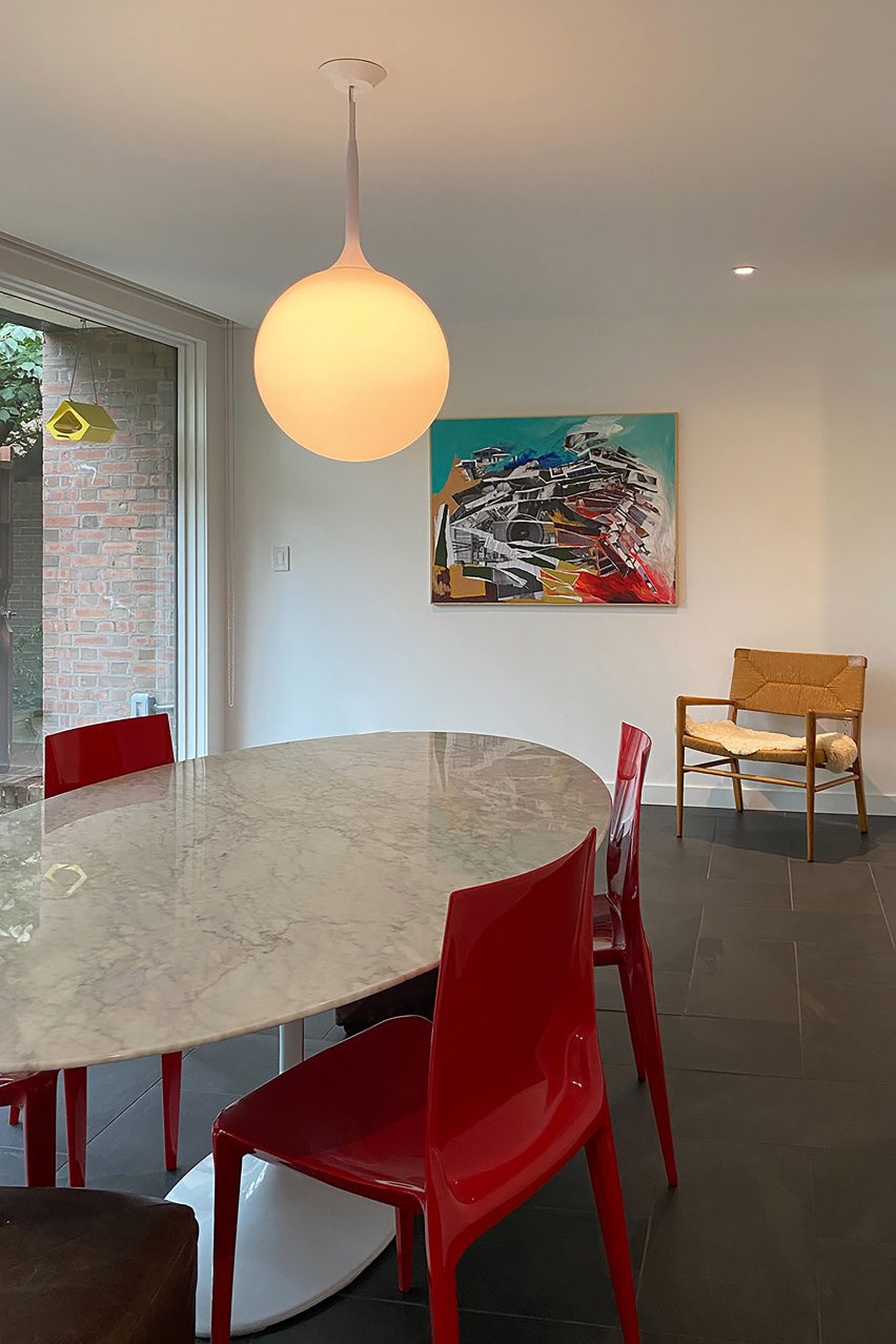 Interior of townhouse with globe pendant light and red chairs