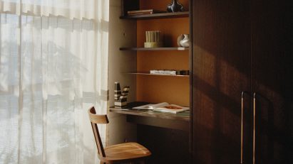 Dark wood desk next to built-in wardrobes in Fisherman's Cottage