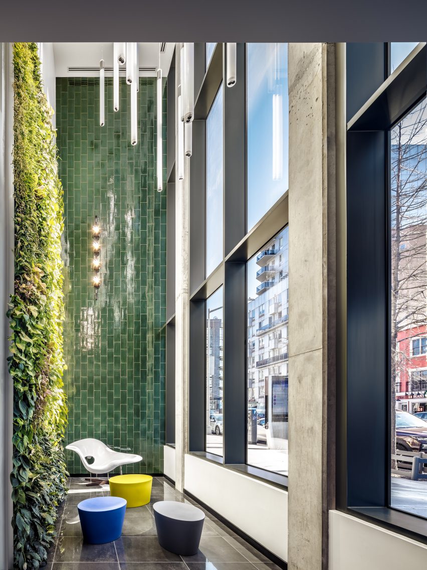 Indoor terrace with large gridded windows and wall lined with terracotta tiles