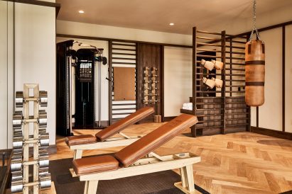 Gym with a tanned leather punching bag and benches