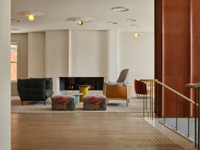 Lounge area in front of undulated plaster fireplace surround