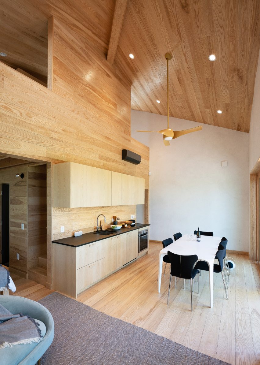 A kitchen with a white table and a double-height ceiling