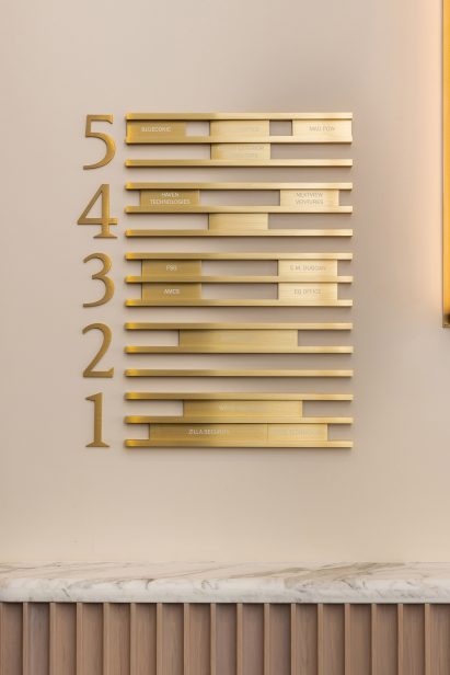Polished brass signage denoting building levels 1-5