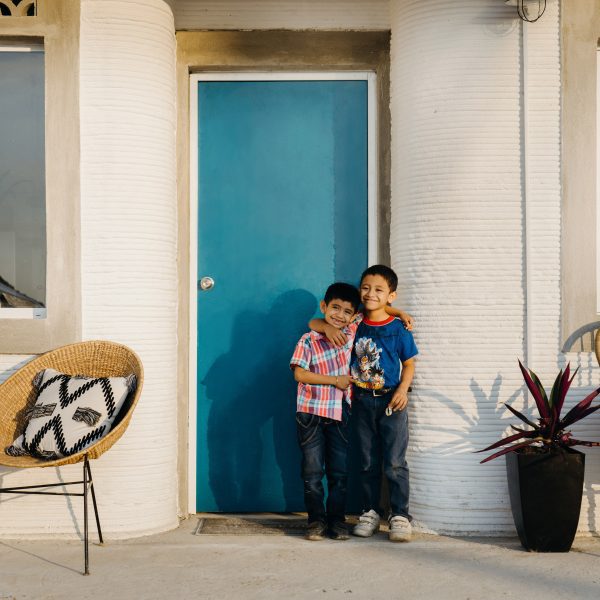 Picture of two young boys standing outside a house