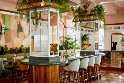 Photograph of the interior, including mirror-adorned columns marble bar tops