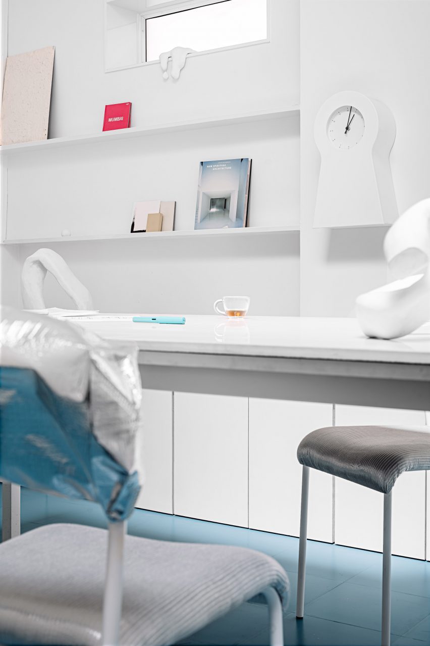 Inside The Act of Quad's studio space, with white furniture and a blue floor
