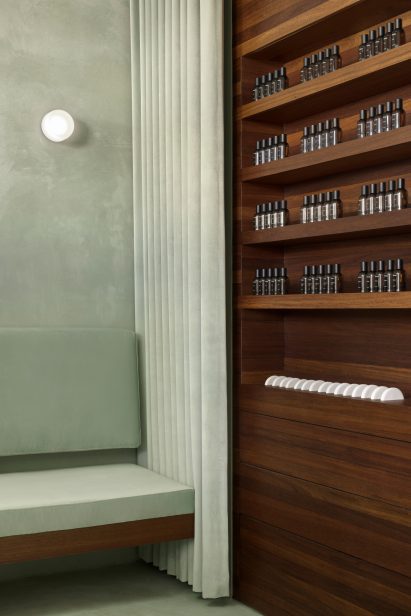 Bench beside products displayed on walnut shelving