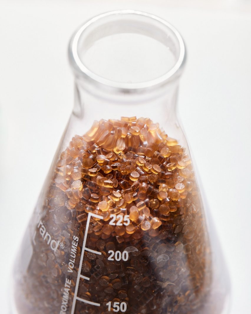 A beaker with small brown pelletes