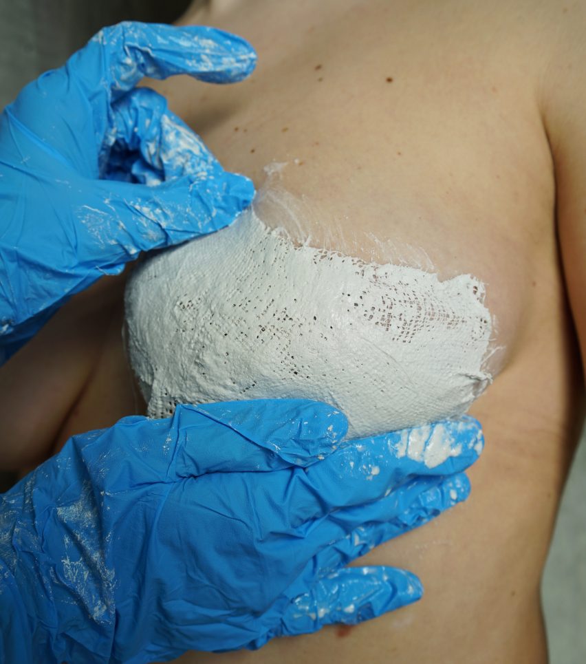Person taking a cast of someone's breast