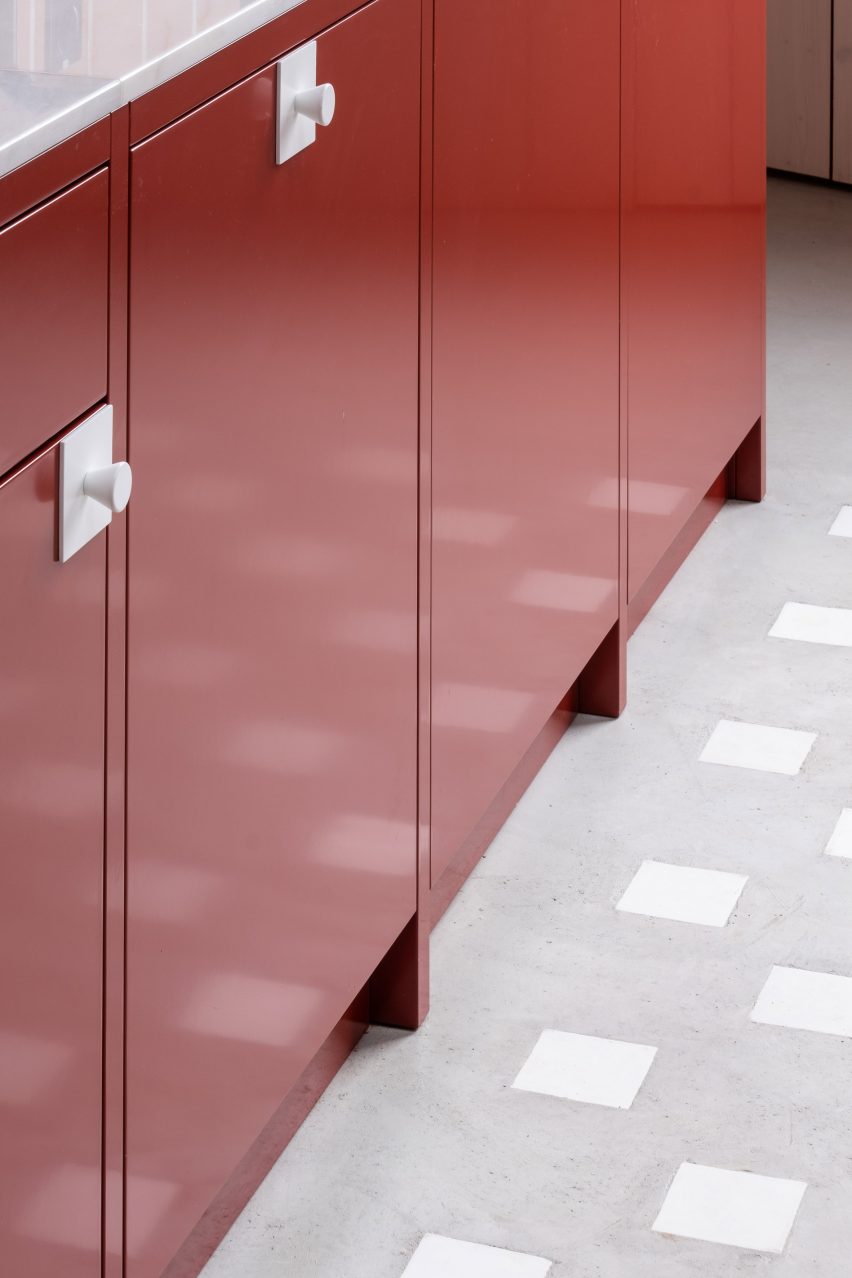 Red metal kitchen units on a concrete floor