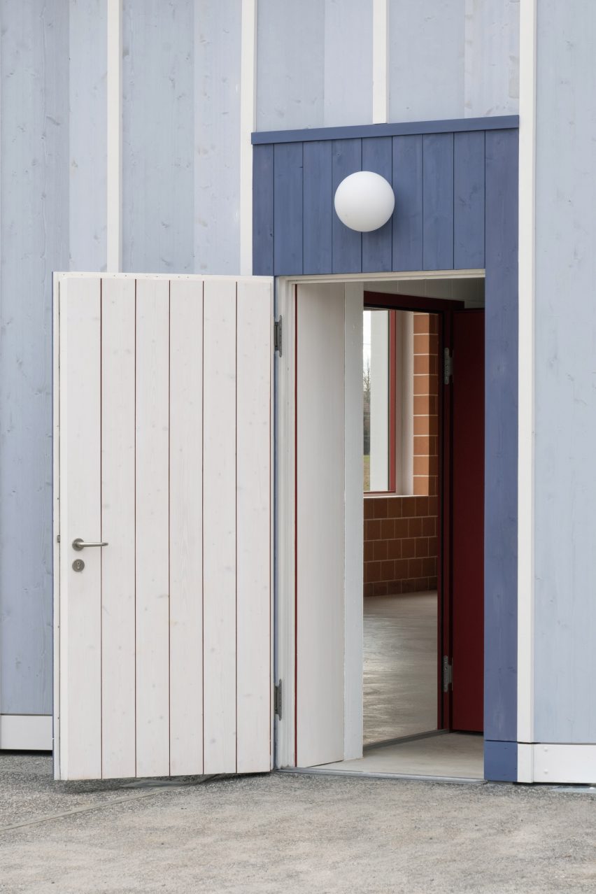 White open door on a blue timber building