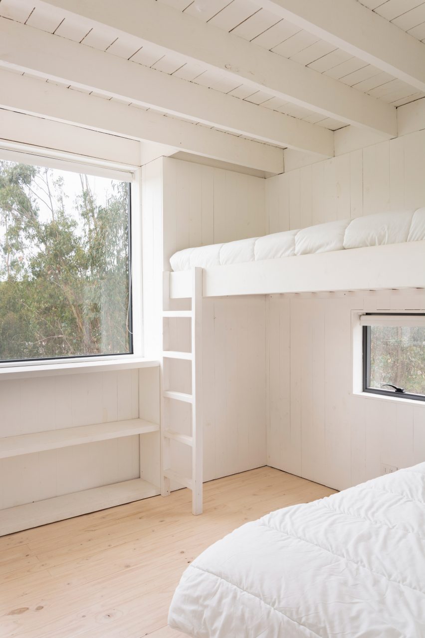 A bedroom with a bunk bed and large window