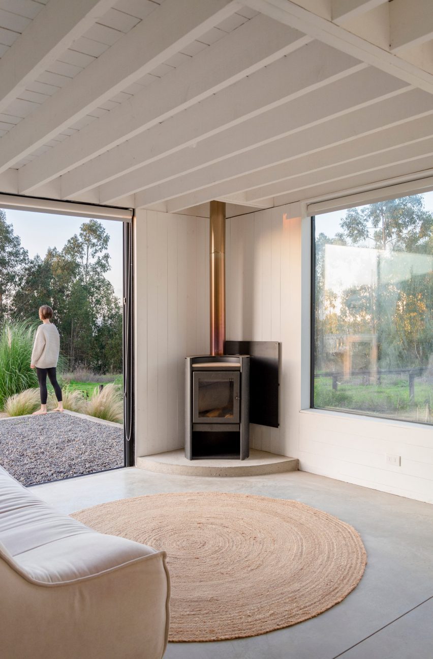 A woodstove in the corner of a living room with concrete floors