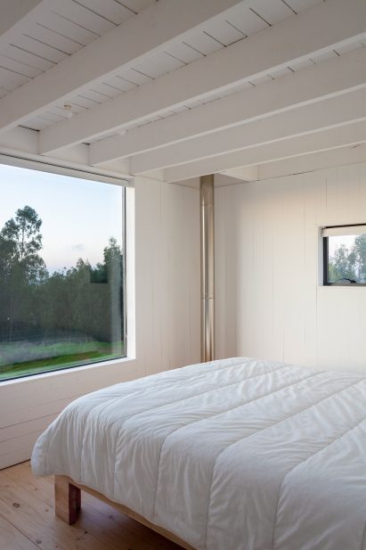 A bedroom with a stove pipe running through it
