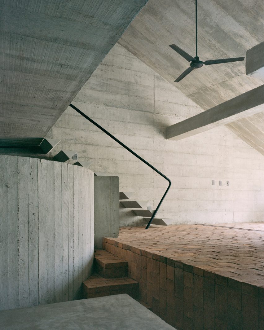 A concrete house with an angular interior and brick floors