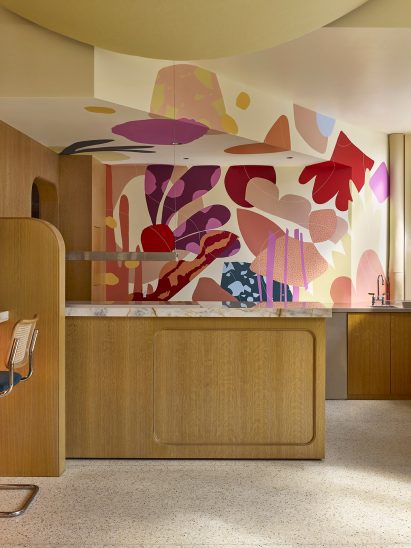Mural by Alex Proba across the wall of an open kitchen