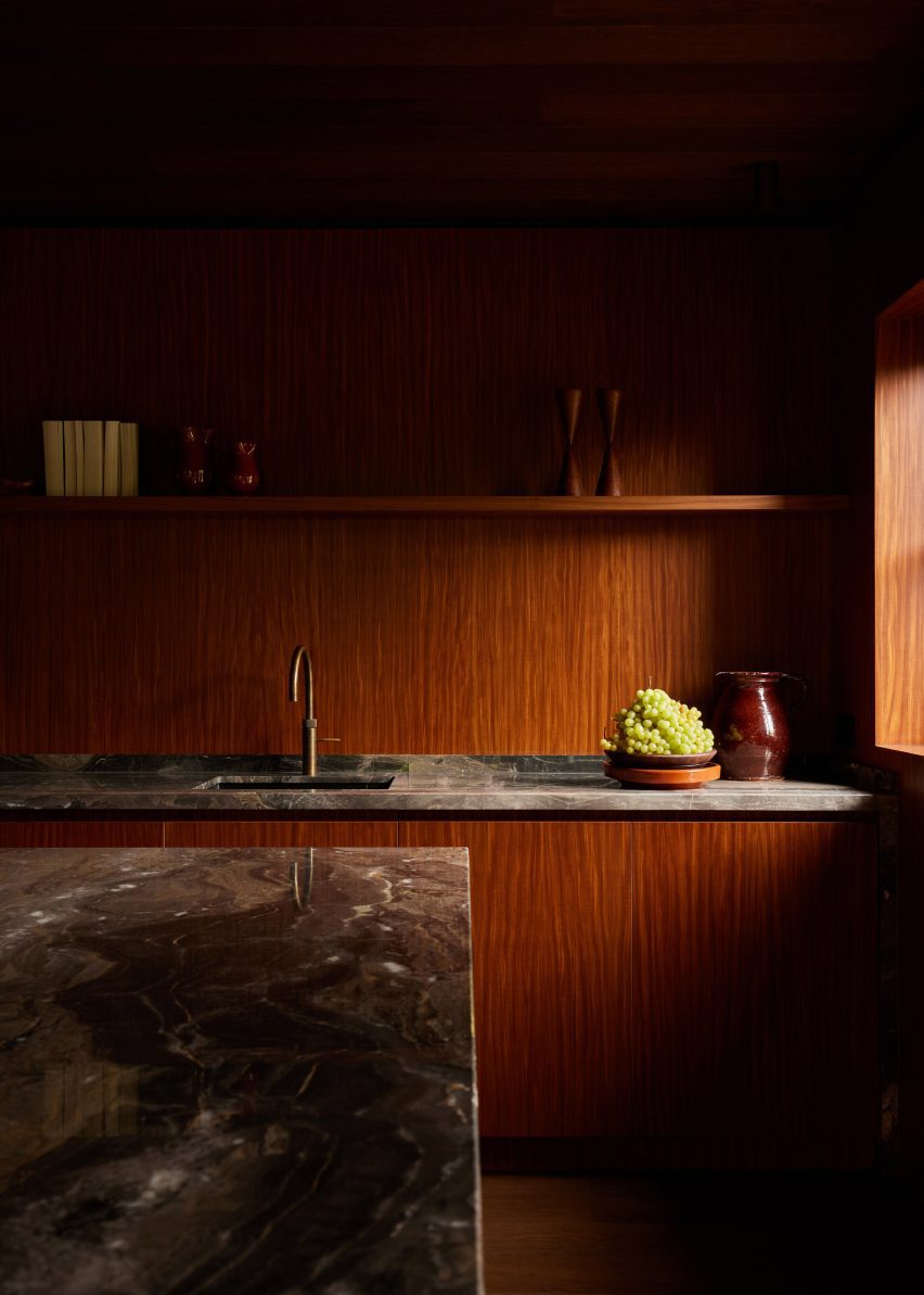 Wood-lined kitchen by DAB Studio with marble worktops