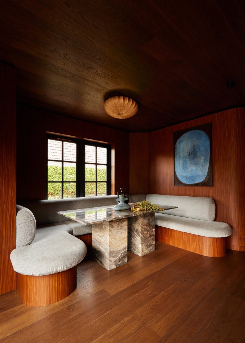 Banquette seating in a dining room nook with wood flooring, ceiling and walls by DAB Studio