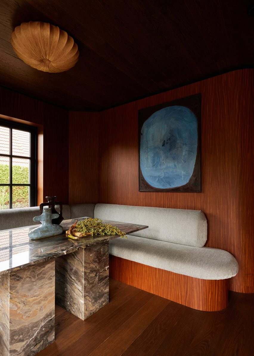 Wood-lined dining nook below a window with built-in seating