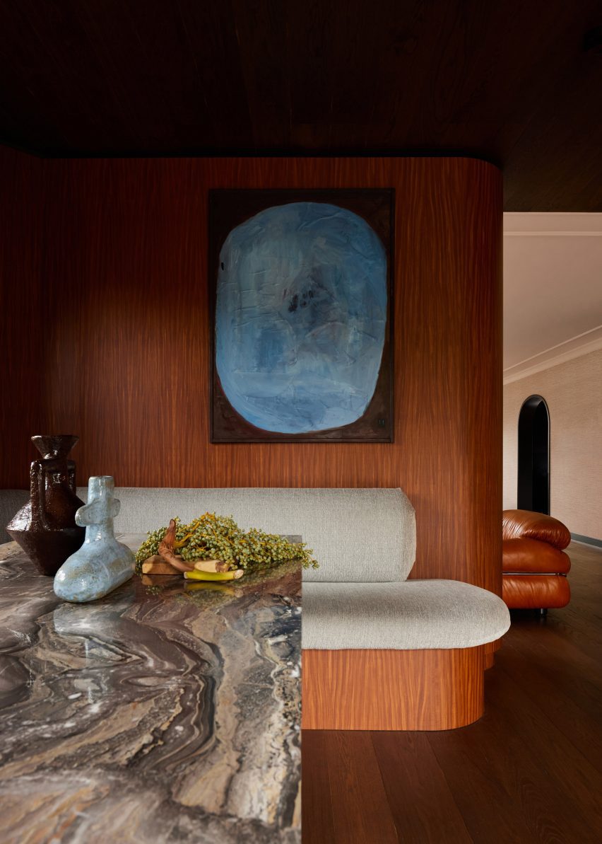 Wood-clad interior with marble table and upholstered bench seating