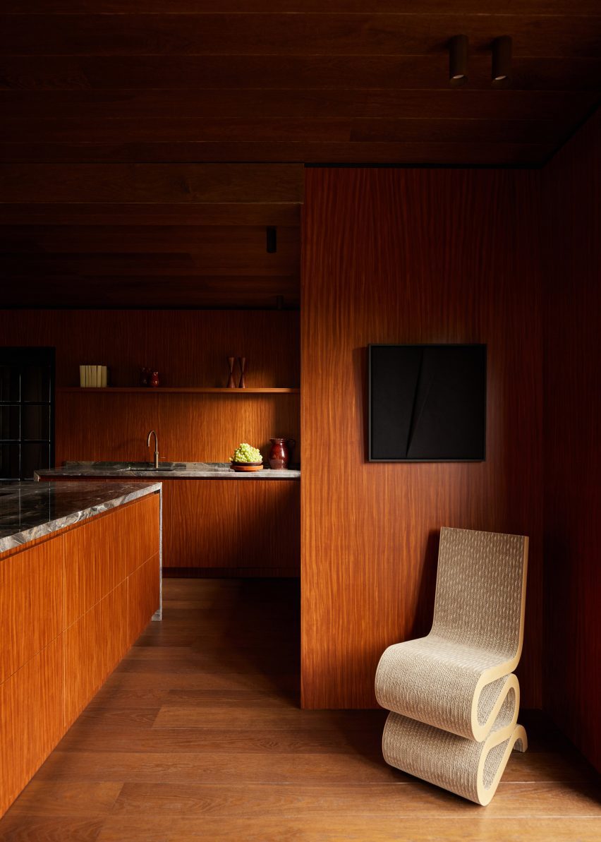 Wood-lined interior with with marble worktops and kitchen island